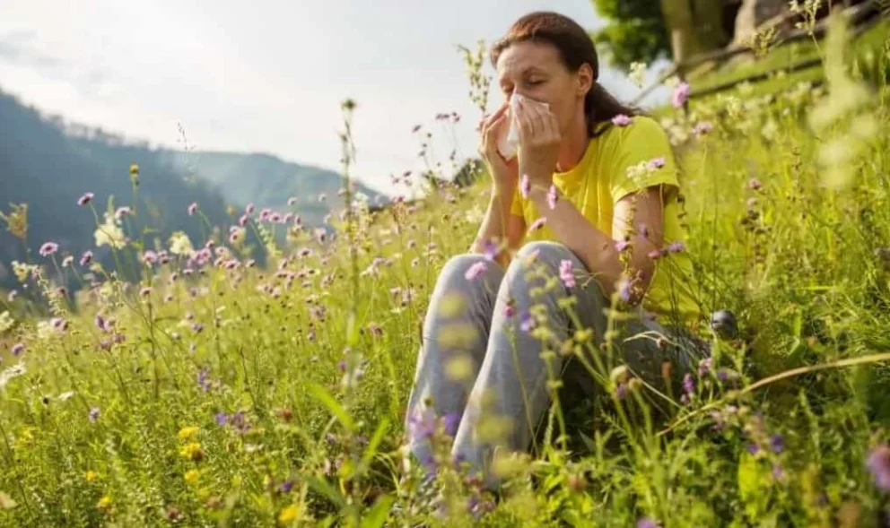 Persona con sintomi di allergia stagionale, naso arrossato e occhi lacrimanti, segni tipici di rinite allergica