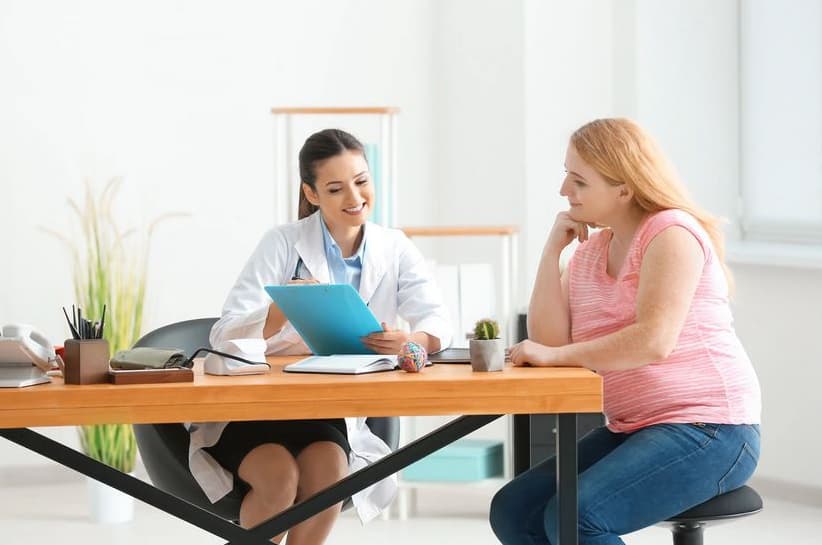 Donna sovrappeso che si consulta con una dottoressa