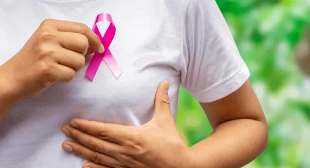 Donna con fiocco rosa simbolo della prevenzione del tumore al seno, rappresentazione della consapevolezza sul fibroadenoma mammario.