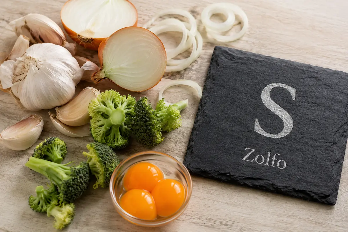 Aglio, cipolla e uova ricchi di zolfo accanto al simbolo chimico S